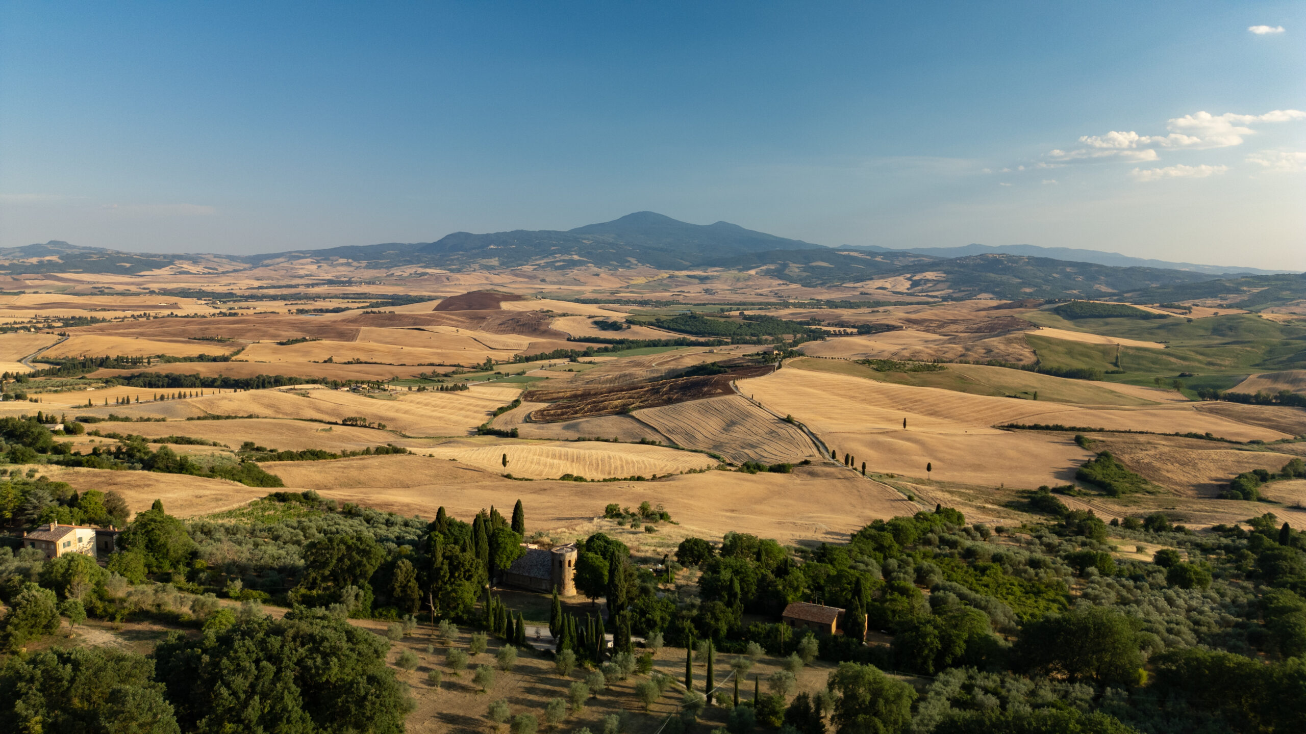 Panoramic view over the rolling hills of Val d'Orcia and the stone village of Castelmuzio