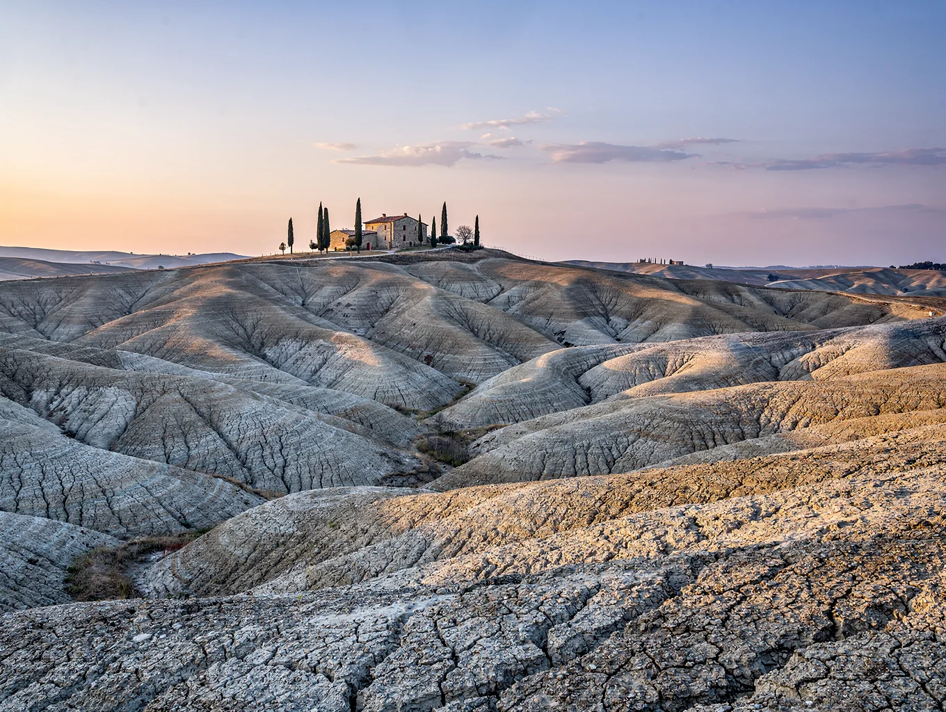 Otherworldly Crete Senesi clay hills with lunar-like badlands and cypress-dotted farmhouses near Siena, Tuscany